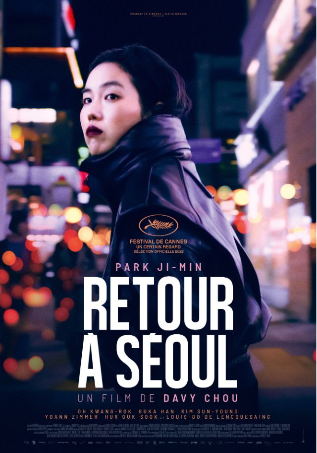 Movie Poster von Rétour à Séoul. Freddie steht auf den nächtlichen Strassen von Seoul und dreht scih mit dem Gesicht zur Kamera.